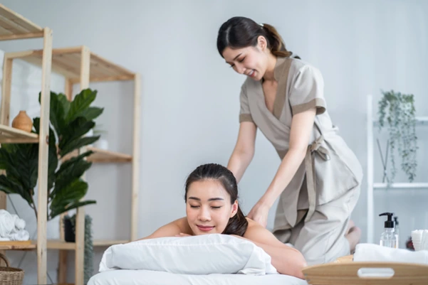 A chiropractor performing a sports massage on a client's neck and shoulders to address posture-related pain