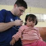 Dr Jeff treating a child's neck in Peru