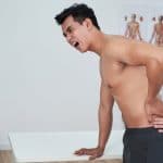 SG Pain Solution Young man suffering severe pain from slipped disc in his lower back