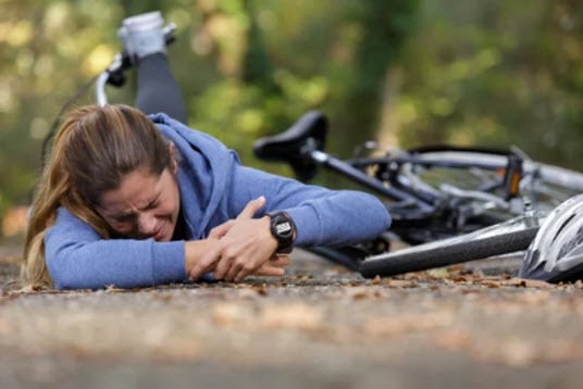 Injured cyclist lying on the ground, showcasing the need for injury treatment