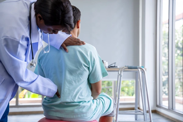 A doctor examining patient’s back condition