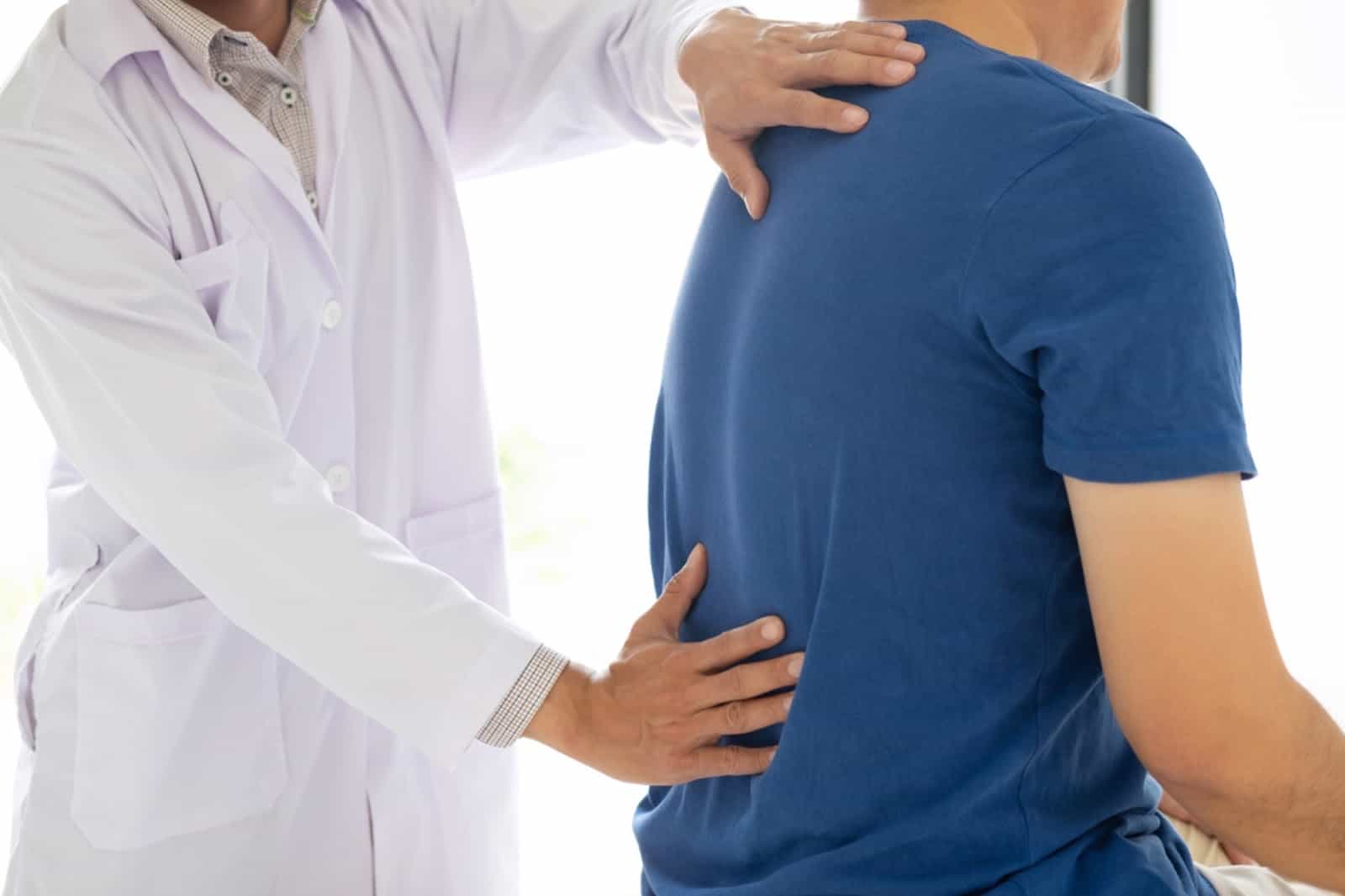 A chiropractor examining a patient's back