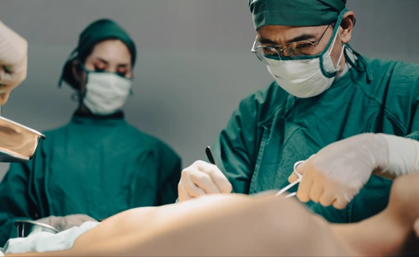 A team of surgeons performing a surgical spinal decompression procedure in a sterile operating room